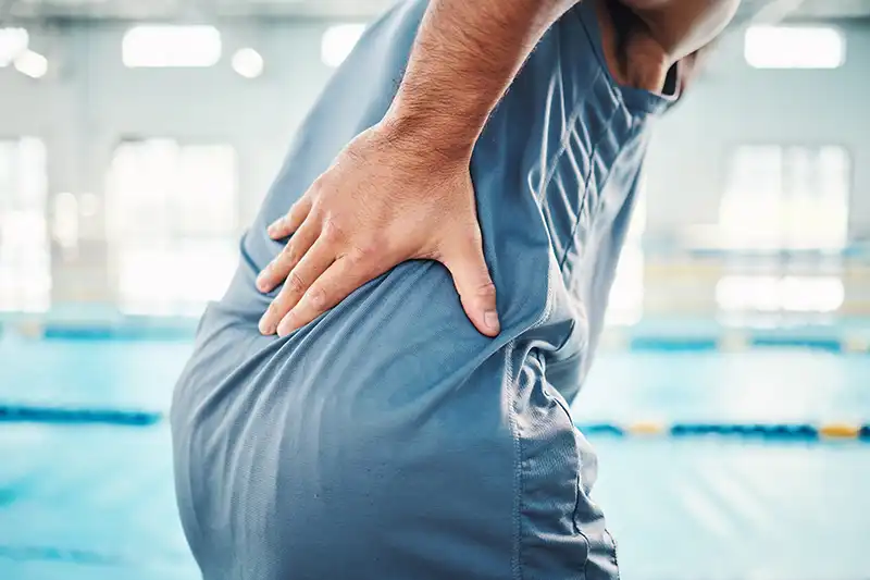 pain in back sports and man by swimming pool